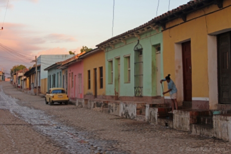 A woman washes the stoop on a cobbled street in Trinidad, Cuba.